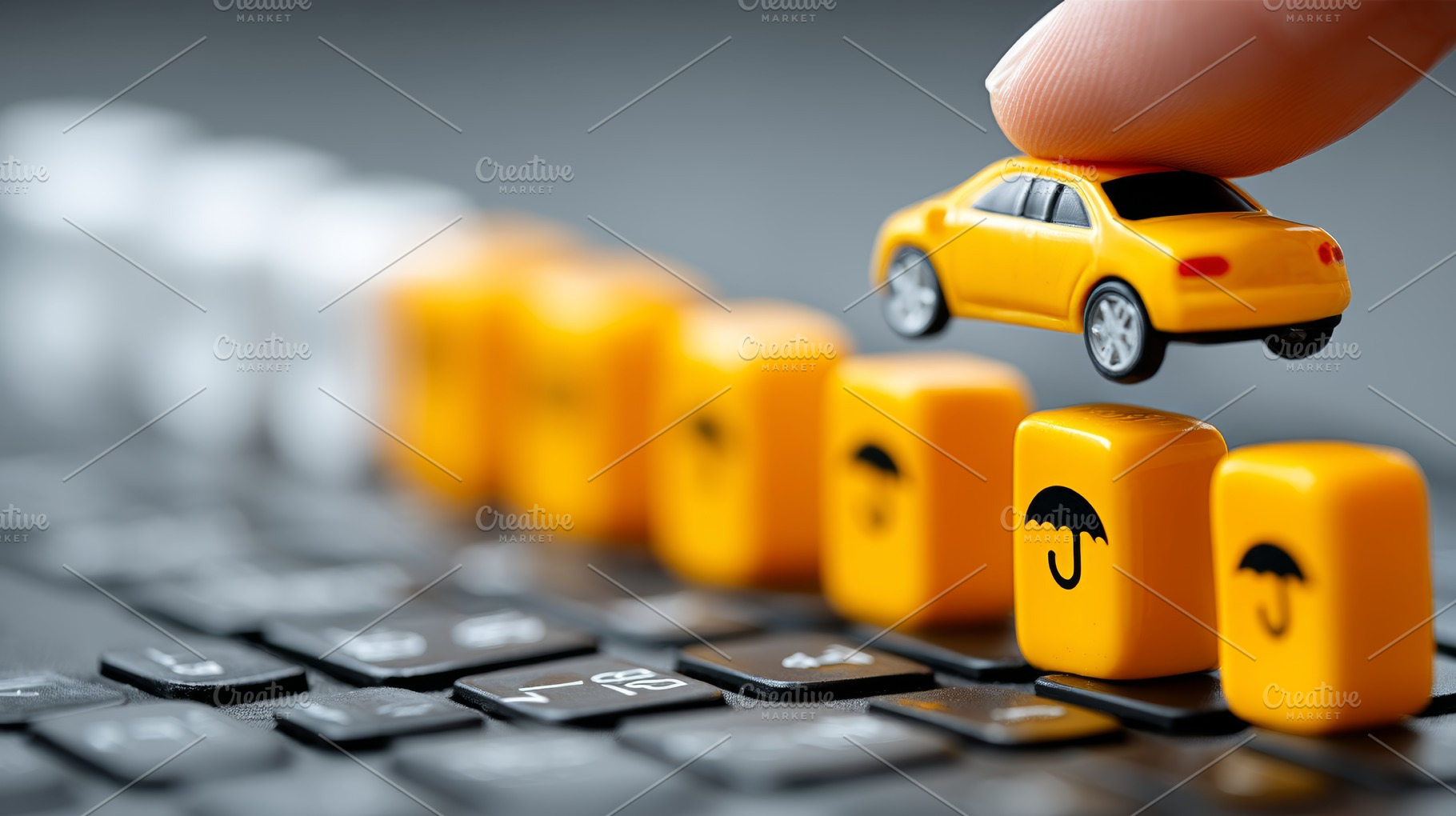 Yellow car and insurance cubes on a keyboard demonstrating protection and cover, a Photo by AS photostudio
