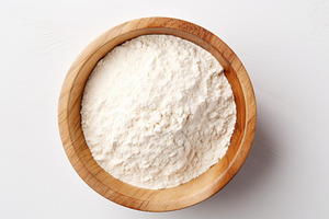 Flour in wooden bowl on white background, a Food & Drink Photo by AlyaAnd