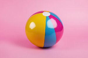 Vibrant beach ball on pastel pink background perfect for summer fun and relaxat, a Sports & Recreation Photo by AlyaAnd