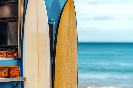 Surfboards by the beach with a food truck parked under a clear sky, a Sports & Recreation Photo by AlyaAnd