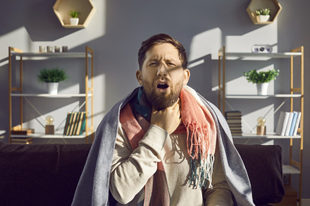 Sick man with touching his neck, a Person Photo by StudioRomantic