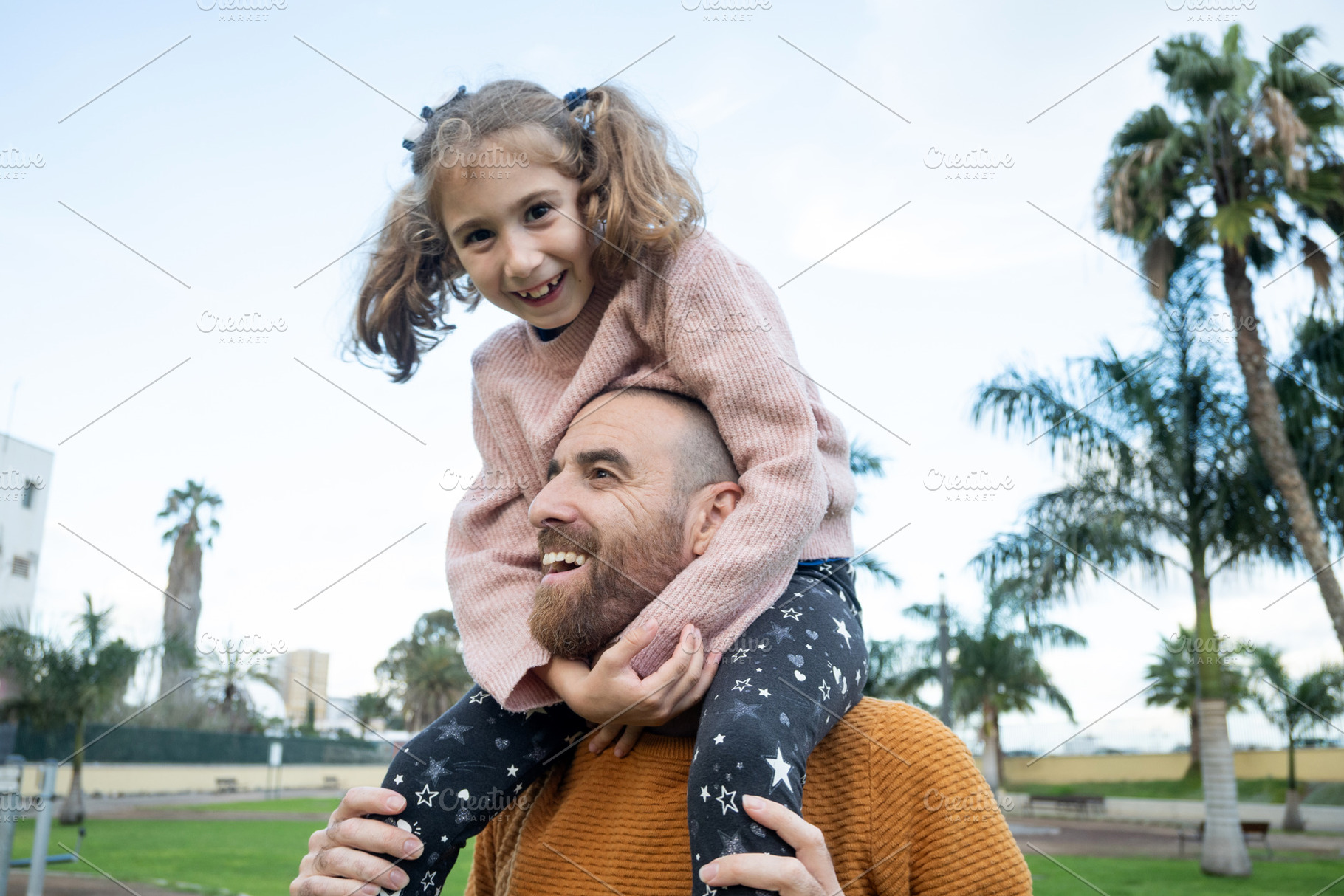 Father carrying his daughter on his shoulders at the park, a Person Photo by etorres69