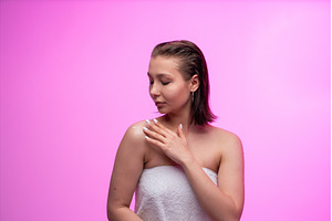 Young woman applies body lotion to, a Person Photo by volodymyrshtun13795