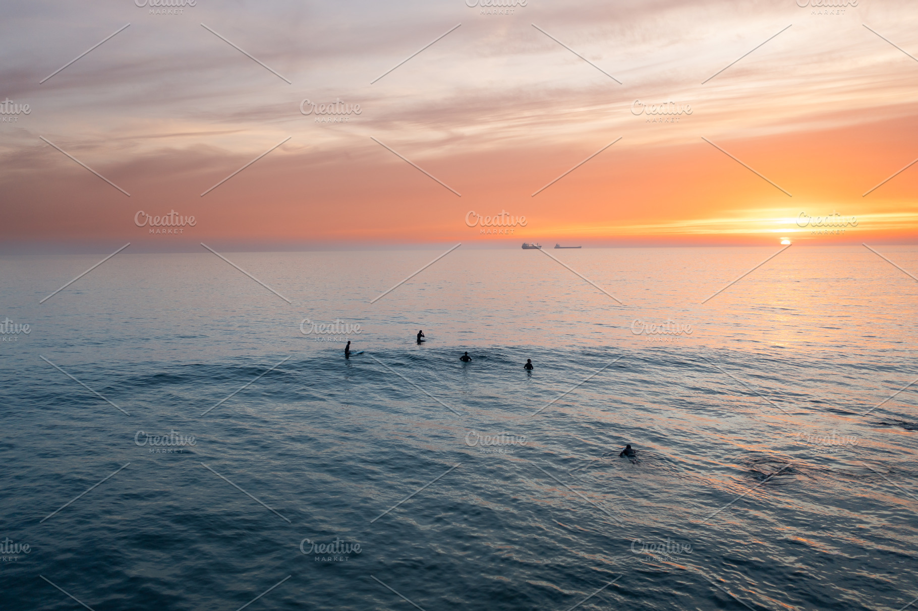 Aerial shot of silhouette people swimming in vast ocean during sunset, a Photo by andreonegin market