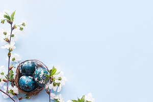 Happy Easter! Easter eggs in nest with cherry blossom flat lay o, a Holiday Photo by Sonjachni