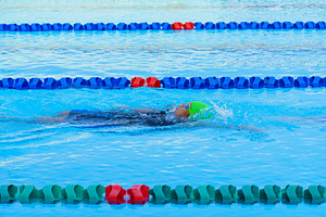 Swimmer child swims backstroke swimming style in a race swimming