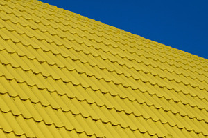 A section of a bright yellow corrugated roof, photographed at an, a Background Photo by ndanko