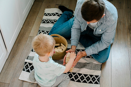 Happy father and toddler boy child little son playing with wooden blocks in chi, a Person Photo by Anikona
