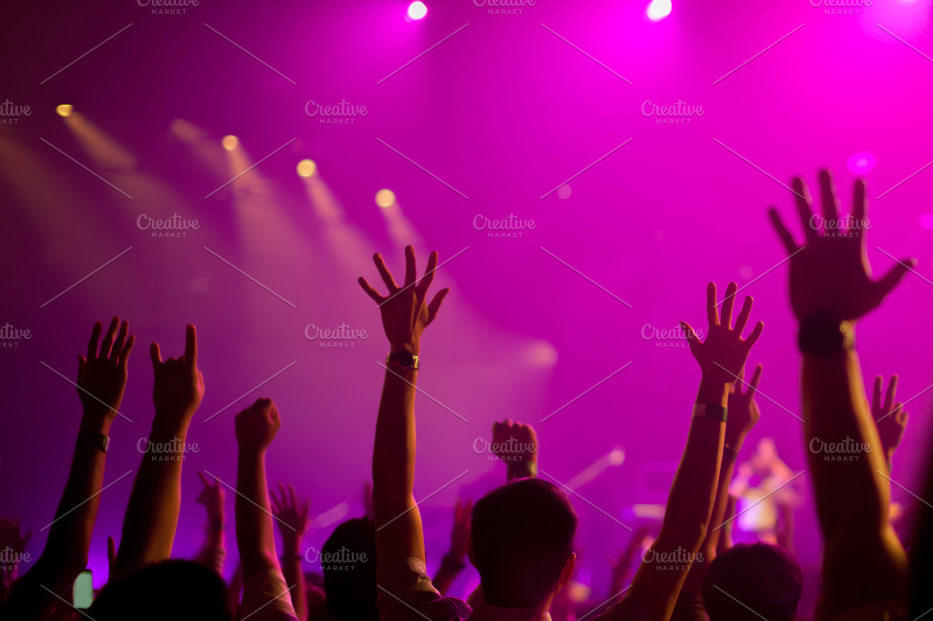Music band crowds raising hands up in the air selective focus containing, an Arts & Entertainment Photo by Twinster Photo