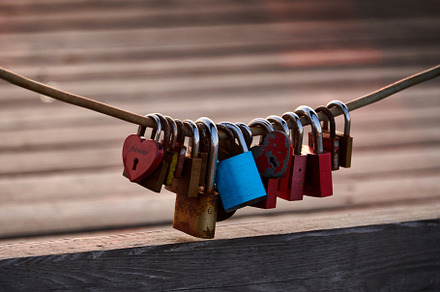 Love locks weathered on a chain on a bridge