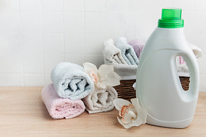 Laundry detergent bottle with fresh clean towels and orchids