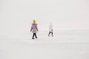 two girls walk on the frozen sea