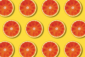 Red orange slices pattern on yellow, a Food & Drink Photo by BOOCYS