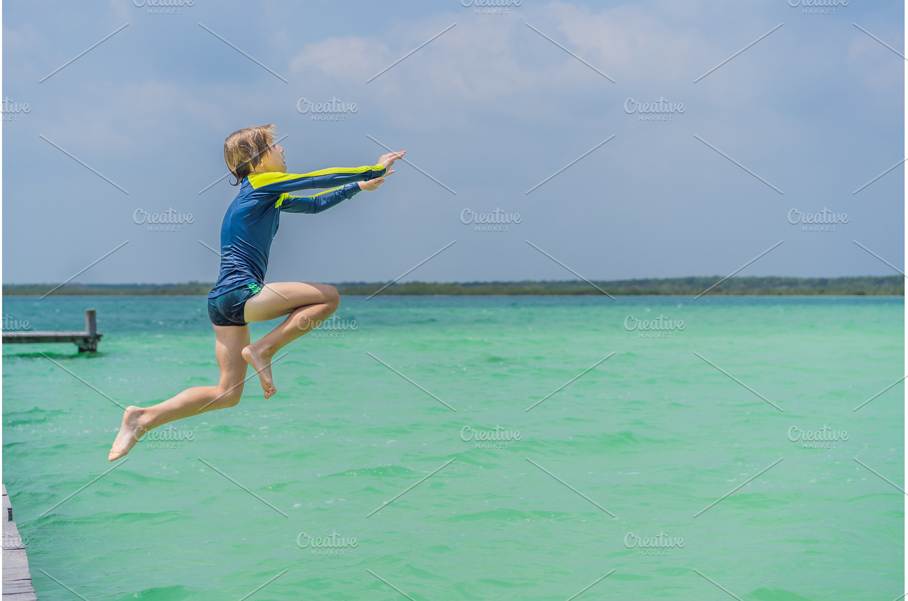 Boy jumping off a pier into a, a Person Photo by Elizaveta Galitskaya