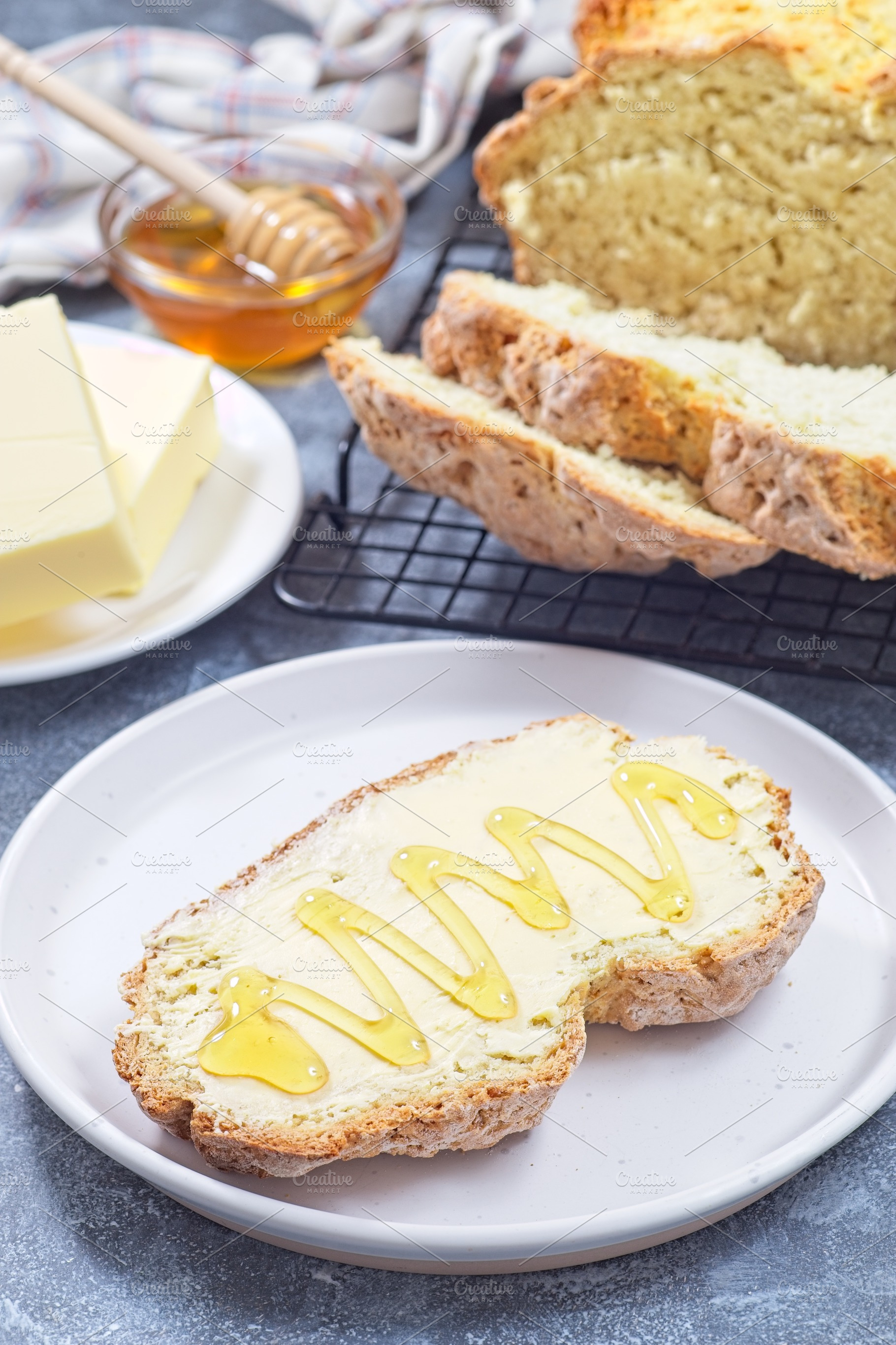 Freshly baked white Irish soda bread with butter and honey served on a plate, v, a Food & Drink Photo by iuliia_n