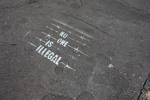 No one is illegal stencil on asphalt street art protesting immigration policy i, a Photo by AS photostudio