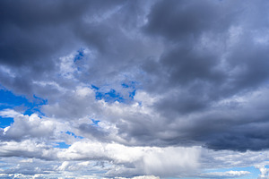 Dark storm clouds with patches of blue sky visible, a Nature Photo by GoodGoods