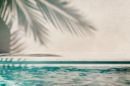Tropical summer background with plaster wall, pool water and pal