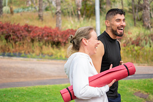 Active couple walking in park after workout carrying yoga mats, a Sports & Recreation Photo by etorres69