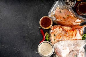 Several bags of marinated chicken meat, a Food & Drink Photo by Rimma