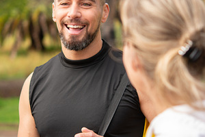 Smiling man talking to woman during outdoor workout session in park, a Sports & Recreation Photo by etorres69