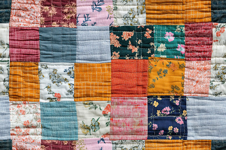Colorful patchwork quilt featuring various floral and geometric patterns. The q, a Texture Graphic by Textures & Backgrounds