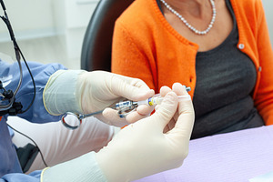 Dentist preparing anesthetic injection for senior patient, a Health & Medical Photo by Antonio Gravante Market