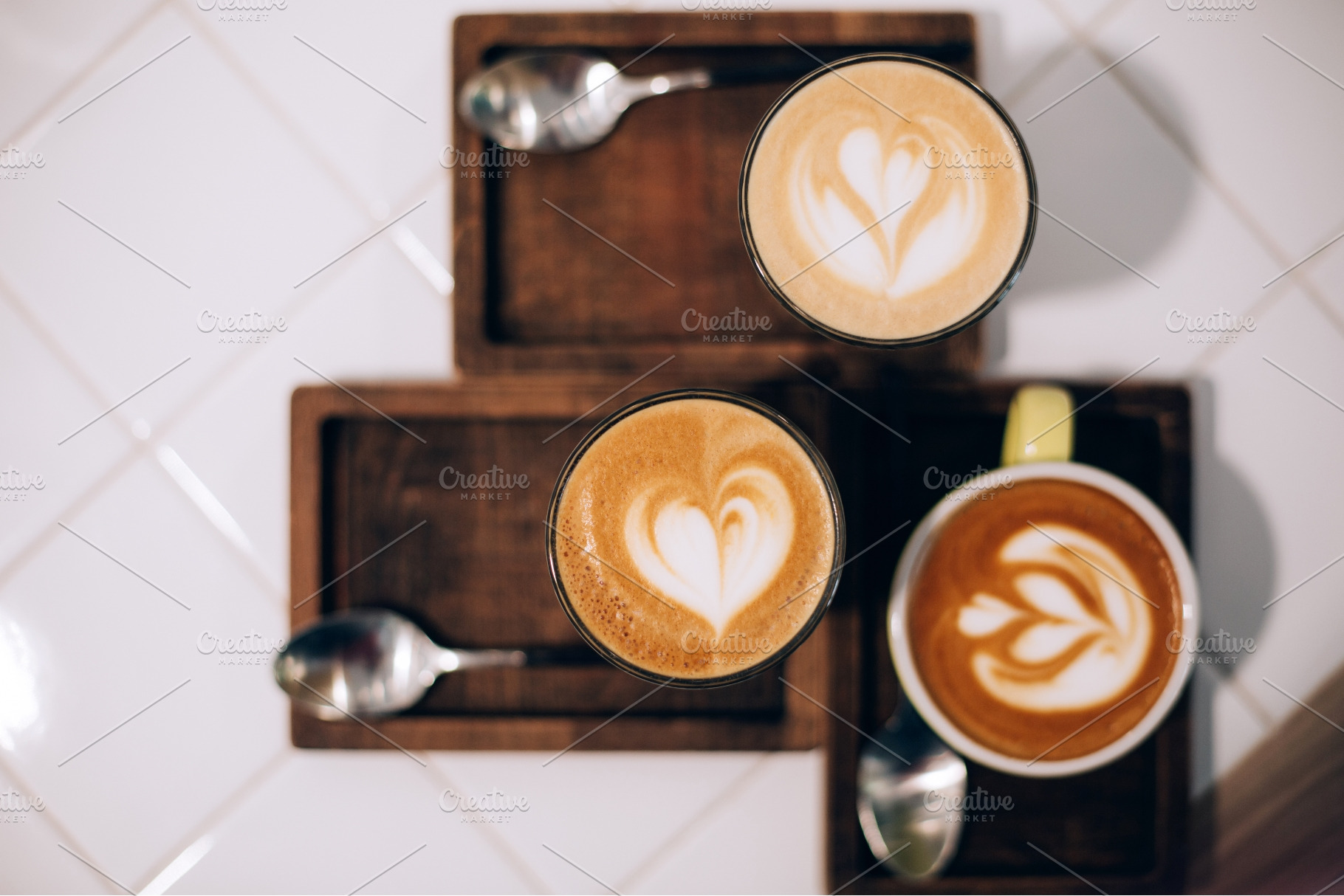 Three cups of latte art coffee on, a Food & Drink Photo by Anna Efetova