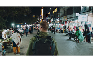 backpacker exploring night market, a Person Photo by Our Amazing World