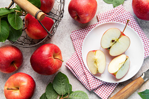 Fresh red apples in basket and sliced on plate, a Food & Drink Photo by Olena Rudo