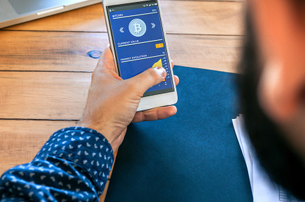 Businessman looking mobile with bitcoins information, a Business Photo by davidpereiras