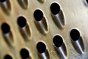 Diagonal macro abstract of an aged metal surface with rhythmic holes. Metallic, a Background Photo by Rohan Photography