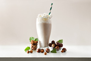 Glass with hazelnut smoothie with cream and bowls beige isolated, a Food & Drink Photo by Davizro's Market