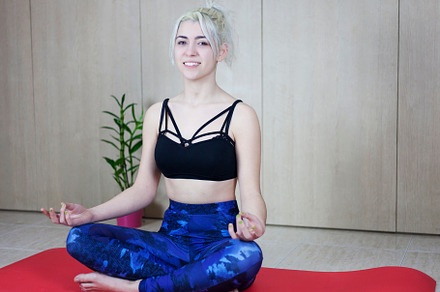 Attractive smiling blonde woman wearing top and trousers sitting on fitness mat, a Sports & Recreation Photo by RF Images
