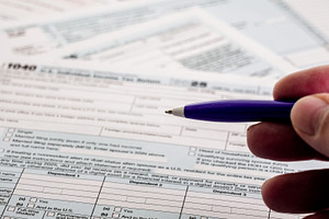 Completing 1040 tax forms with a pen