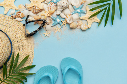 Summer accessories lying on blue background with copy space