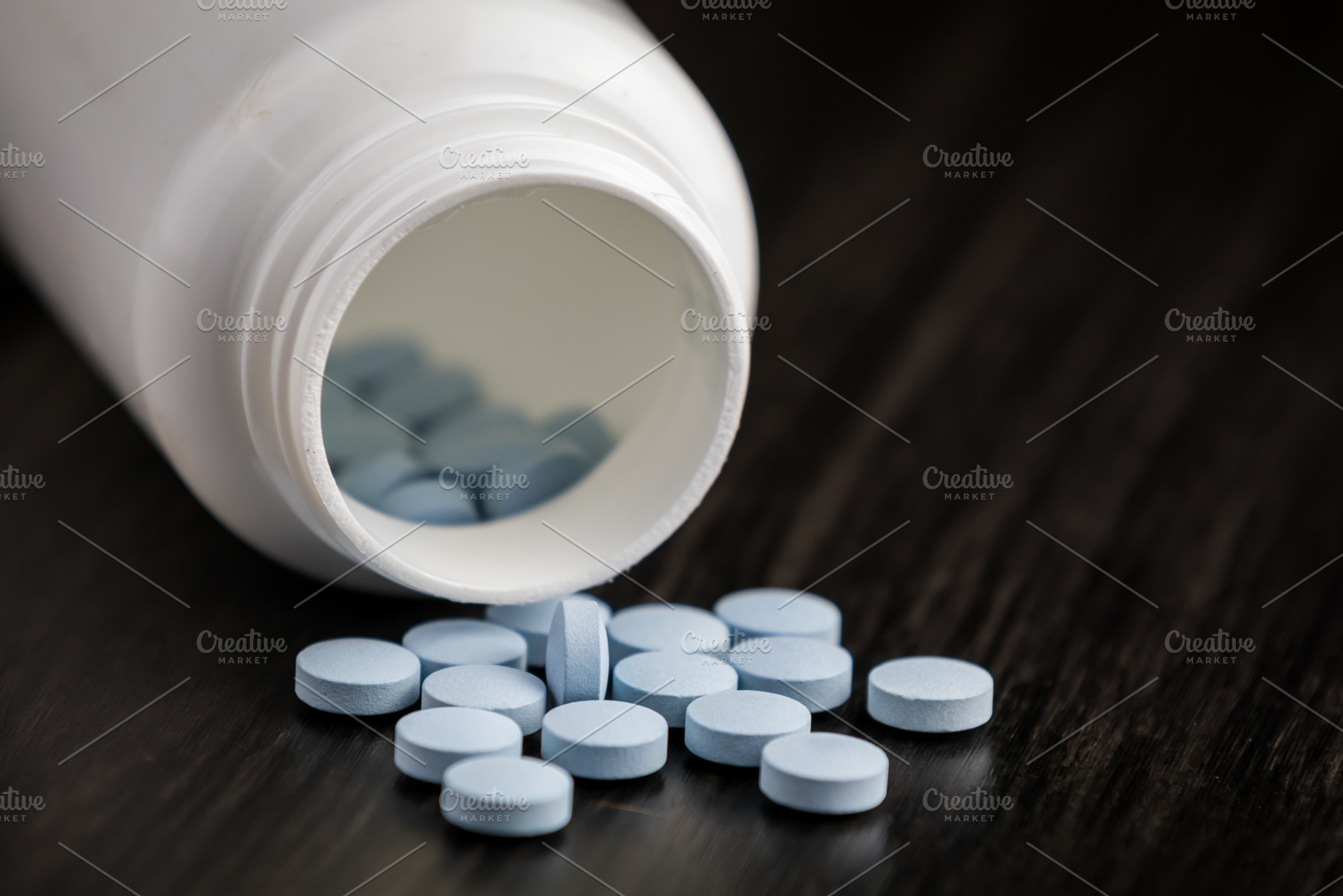 Medication bottle and blue pills spi, a Background Photo by Daniel Megias