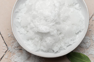 Magnesium chloride flakes in a bowl for spa treatment on tiled s, a Beauty & Fashion Photo by Olena Rudo