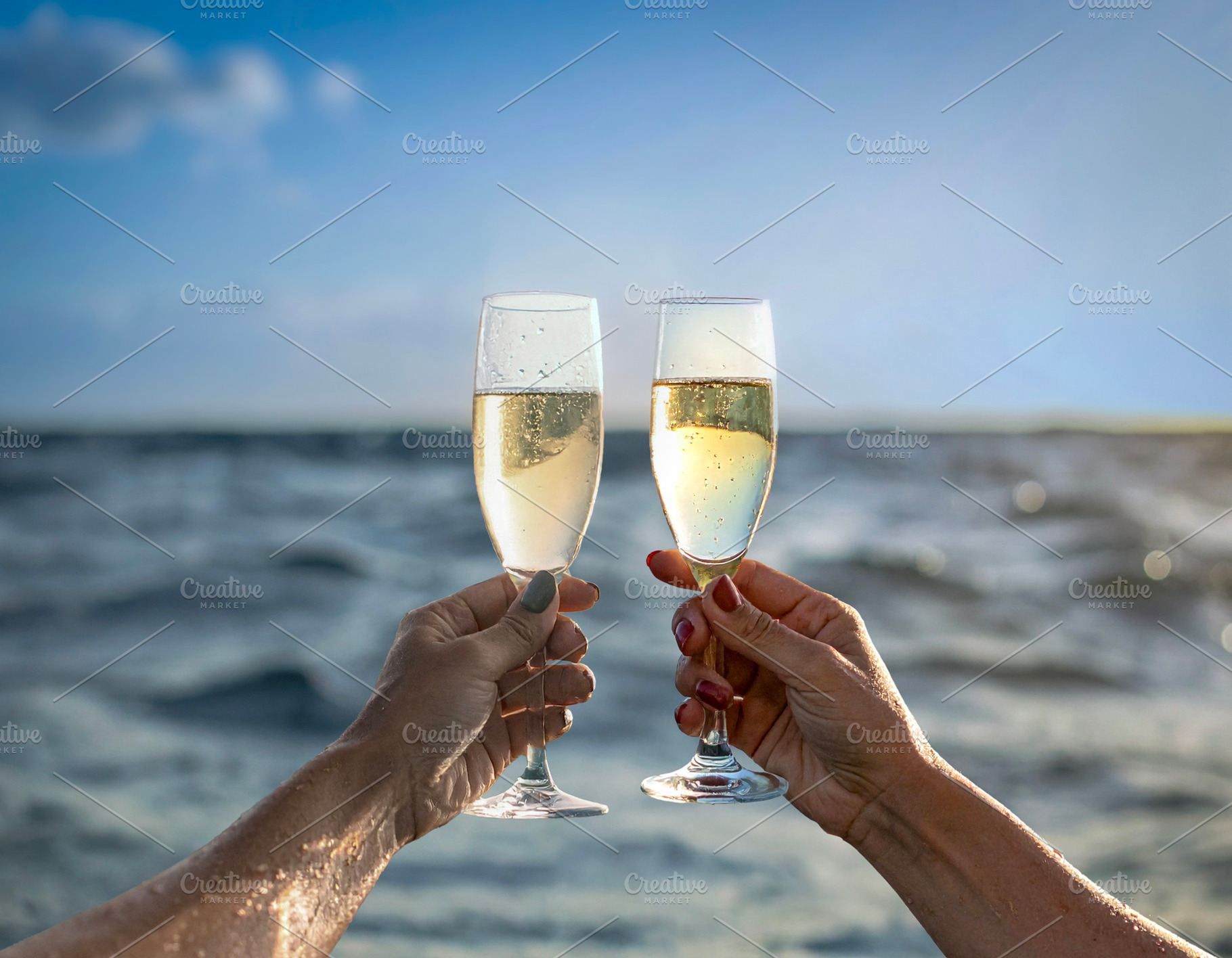Arm raising a champagne glass from the middle of the sea, a Food & Drink Photo by DanFLCreativo