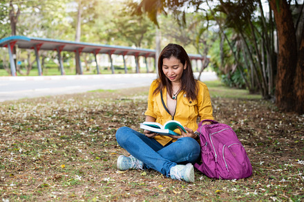 Happy Asian woman sitting and reading books in university park u, a School & Education Photo by Ministocker
