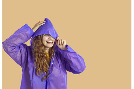 Happy young woman in purple raincoat, a Person Photo by StudioRomantic