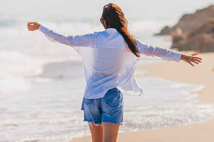 Young happy woman on the beach enjoy her summer vacation. Girl is happy and cal, a Person Photo by travnikovstudio