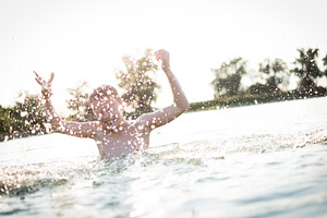 Boy having fun in a lake containing outdoor, wet, and fun