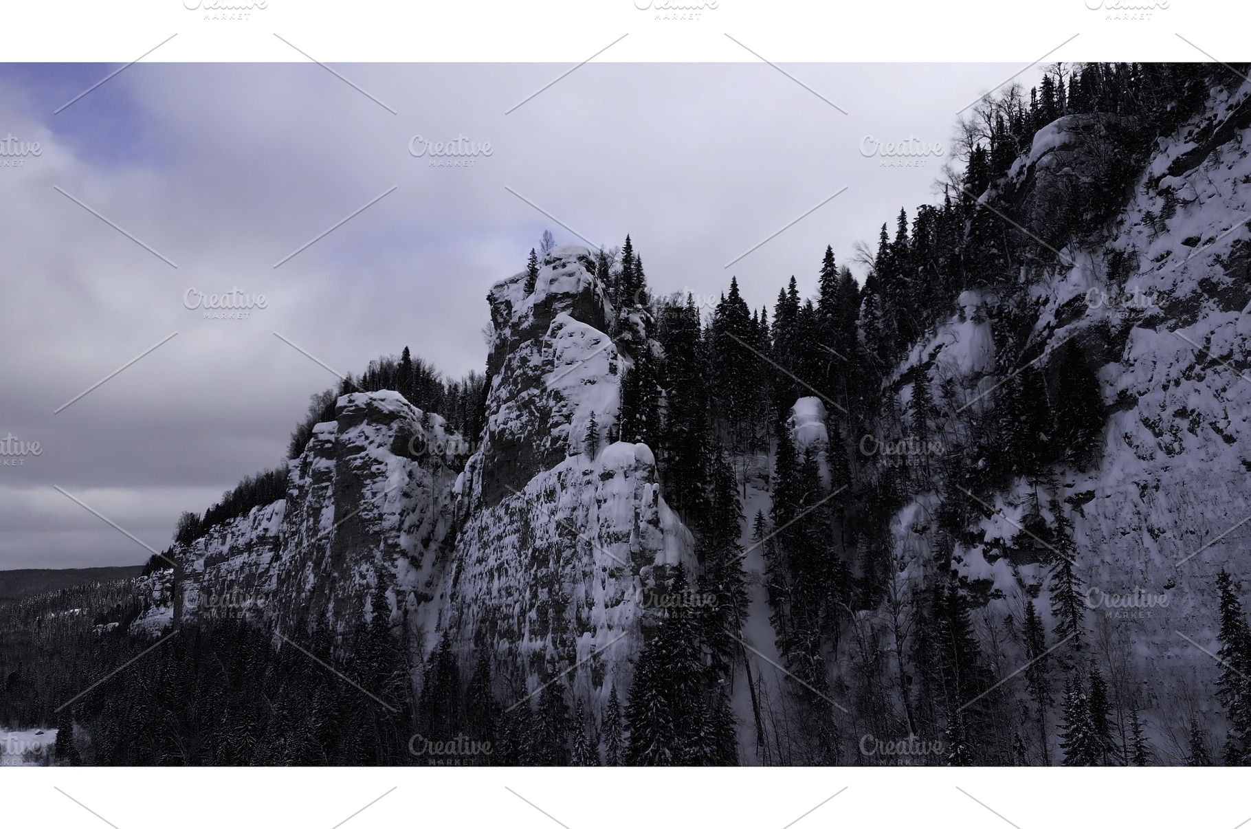 Snow covered stone cliffs with pine, a Nature Photo by Media Whale Stock
