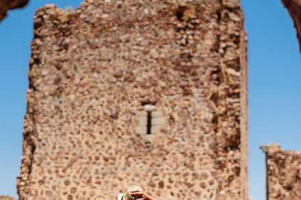 Tourist looking at the wall of a medieval castle., a Holiday Photo by Iván Moreno STOCK PHOTO