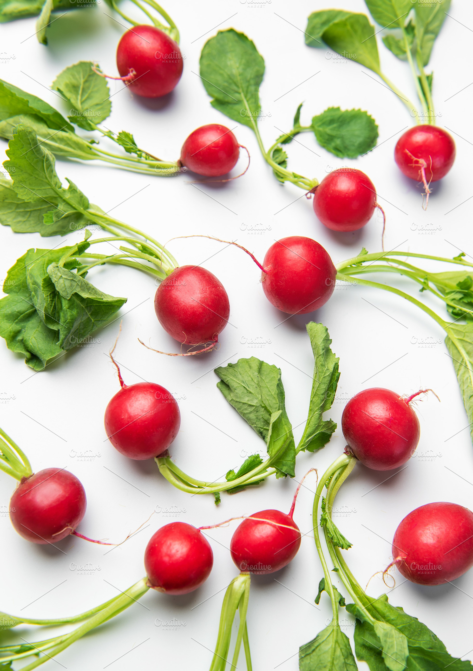 Fresh red radishes with leaves on white background, a Food & Drink Photo by Olena Rudo