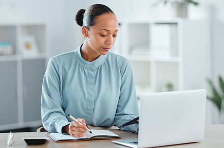 Busy, smart and serious business manager with a laptop working on schedule, planning and brainstorming ideas inside office. Lady marketing analyst writing strategy points for project plan in a diary, a Photo by Peopleimages.com