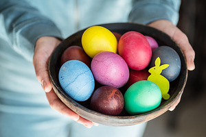 Colorful Easter eggs in bowl in woma, a Photo by Volff