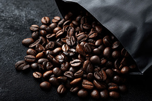 Coffee beans tumble out of a black, a Photo by Pavel_design