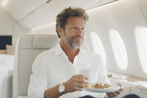 Man enjoying meal on airplane in bus, a Photo by Dvoevnore photos